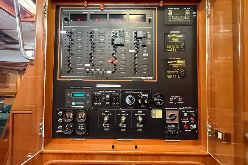 Slide: The Image of Control panel of a 1997 Taswell 50 yacht, featuring various switches and gauges. - 28