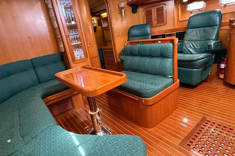 Slide: The Image of Luxurious 1997 Taswell 50 yacht interior with elegant wood finish and plush green seating. - 3