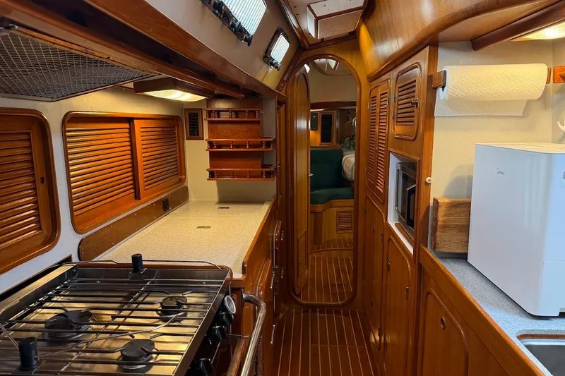 Slide: The Image of Interior of a 1997 Taswell 50 yacht featuring a well-equipped kitchen and wooden cabinetry. - 4