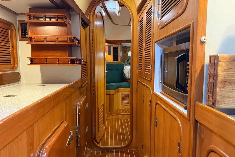 Slide: The Image of Interior of a 1997 Taswell 50 yacht, featuring wooden cabinetry and a cozy cabin. - 5
