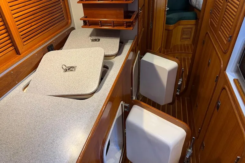 Slide: The Image of Interior of a 1997 Taswell 50 yacht featuring a wooden galley with storage compartments. - 8
