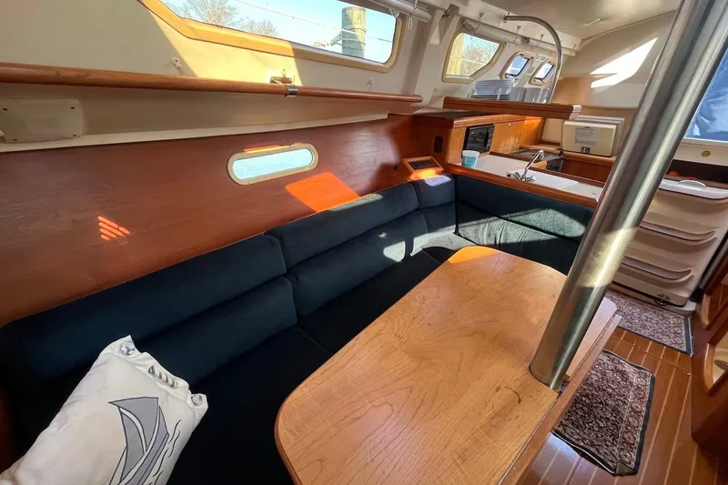 Slide: The Image of Interior of 2002 Hunter 326 sailboat with cozy seating and wooden table. - 10