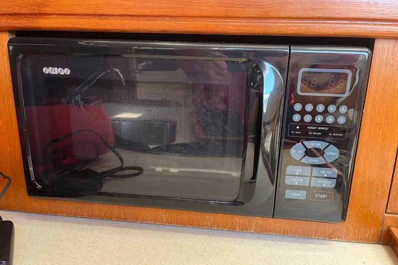 Slide: The Image of Built-in microwave in a 2002 Hunter 326 yacht, featuring digital controls and wood paneling. - 14