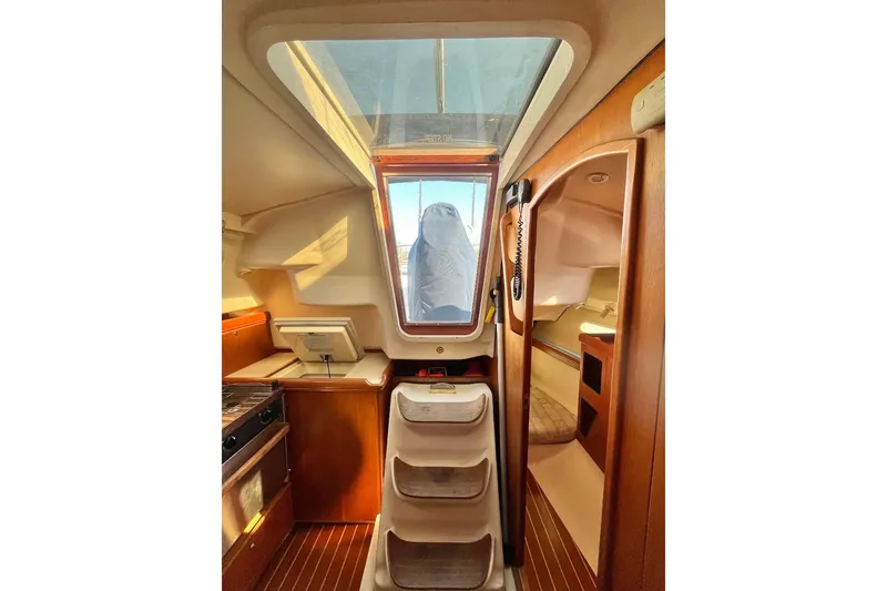 Slide: The Image of Interior of a 2002 Hunter 326 sailboat, featuring a compact kitchen and cozy cabin space. - 15