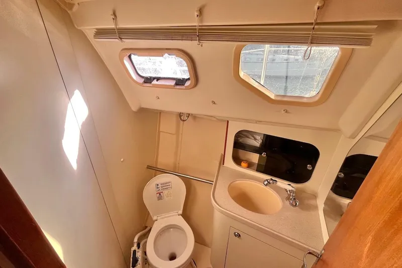 Slide: The Image of Compact bathroom in 2002 Hunter 326 sailboat with toilet, sink, and windows. - 16