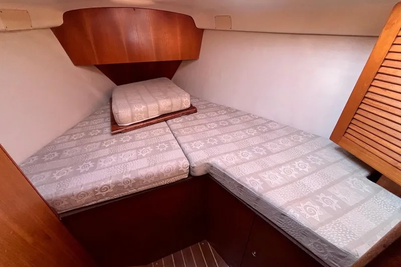 Slide: The Image of Cozy cabin interior of 2002 Hunter 326 sailboat with patterned bedding. - 17