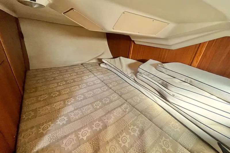 Slide: The Image of Cozy cabin interior of 2002 Hunter 326 sailboat with patterned bedding. - 19