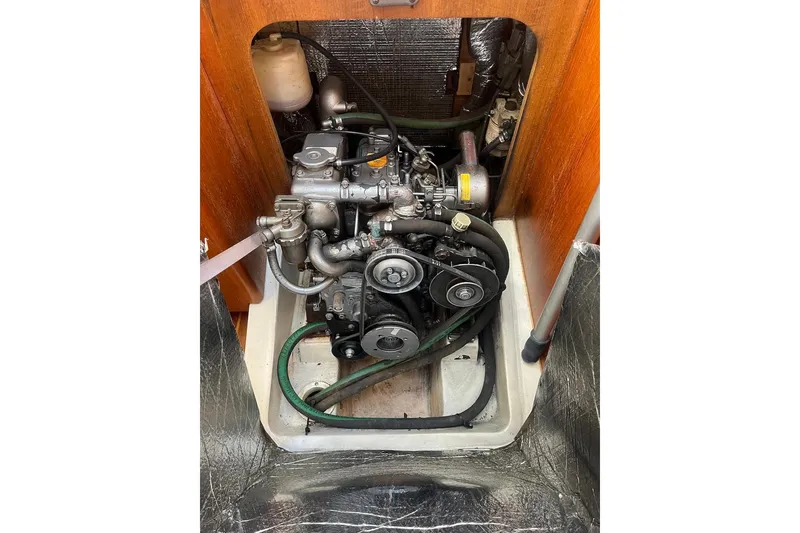Slide: The Image of Engine compartment of a 2002 Hunter 326 sailboat, showcasing mechanical components and belts. - 21