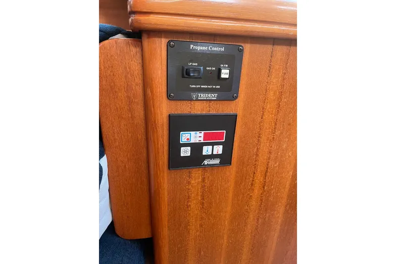Slide: The Image of Wooden panel with propane and air control switches on a 2002 Hunter 326 boat. - 22