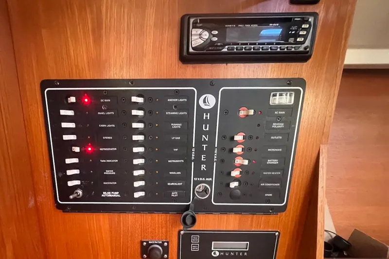 Slide: The Image of Control panel of a 2002 Hunter 326 sailboat with various switches and a stereo system. - 23