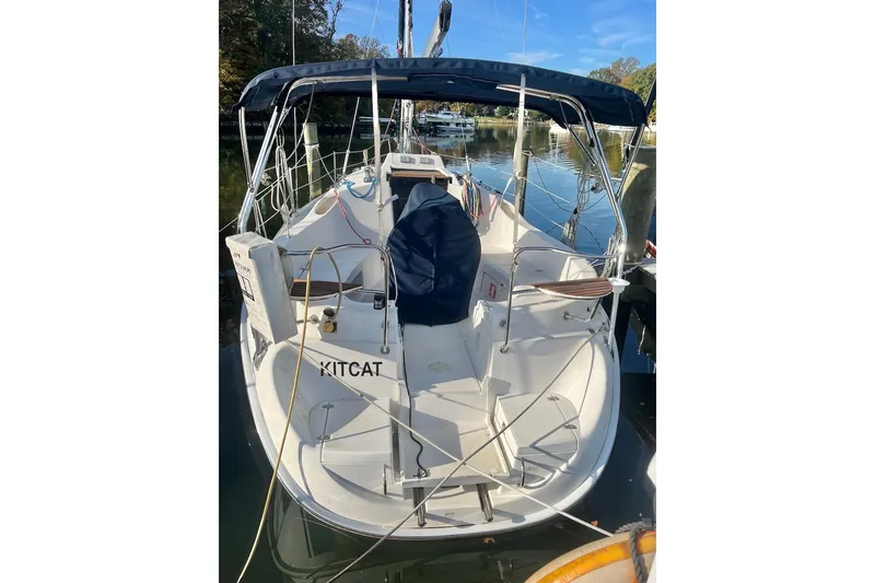 Slide: The Image of 2002 Hunter 326 sailboat docked, featuring a covered cockpit and sleek design. - 6