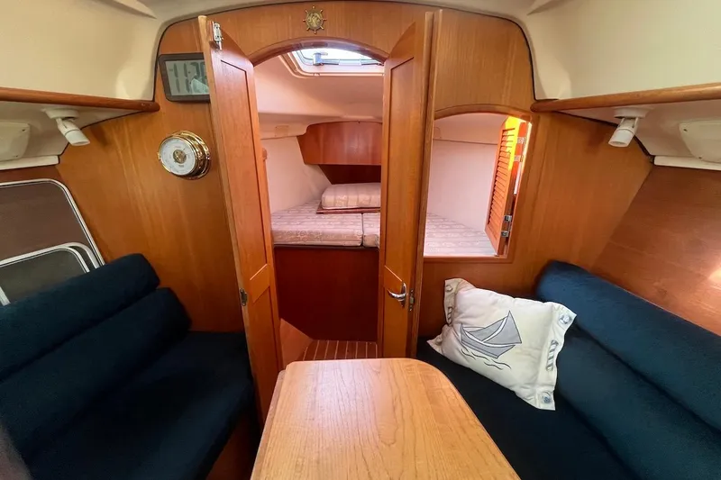 Slide: The Image of Interior of 2002 Hunter 326 sailboat with cozy seating and wooden finishes. - 8