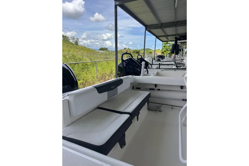 Slide: The Image of 2023 Robalo R222 Explorer boat interior with seating under a covered dock. - 11