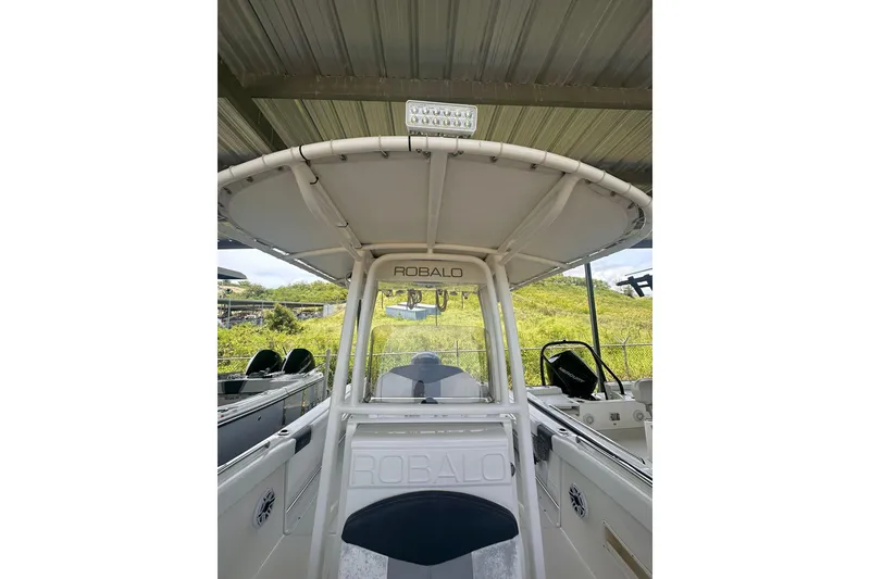 Slide: The Image of 2023 Robalo R222 Explorer boat under shelter, showcasing helm and seating area. - 15