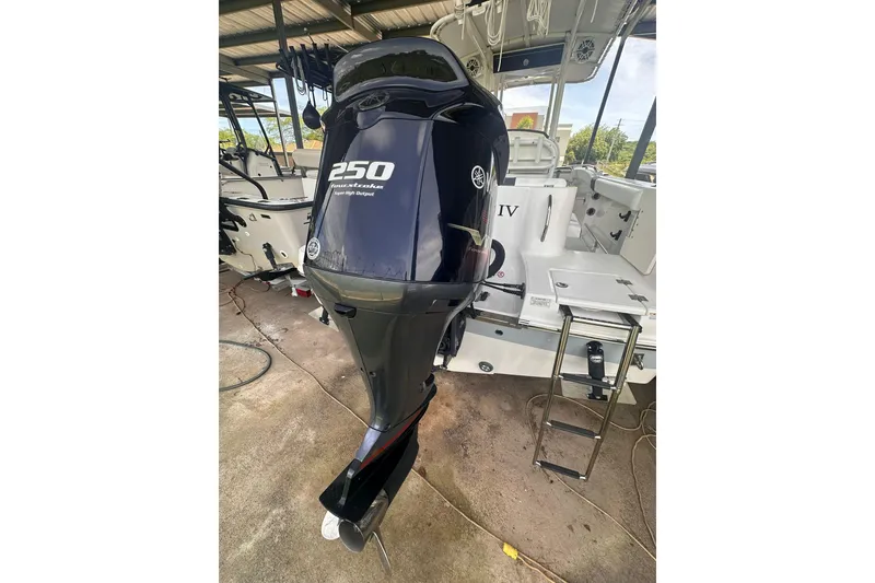 Slide: The Image of 2023 Robalo R222 Explorer with Yamaha 250 outboard motor in a covered dock. - 3