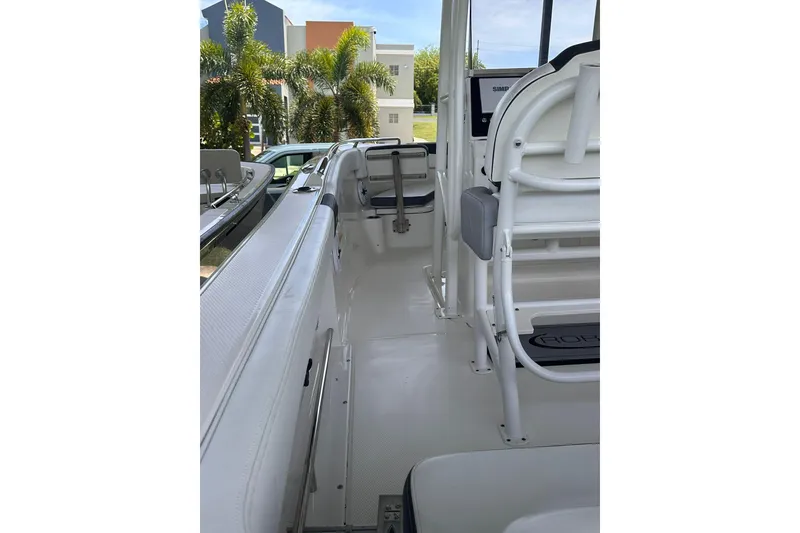 Slide: The Image of 2023 Robalo R222 Explorer boat interior with seating and console, surrounded by tropical greenery. - 5
