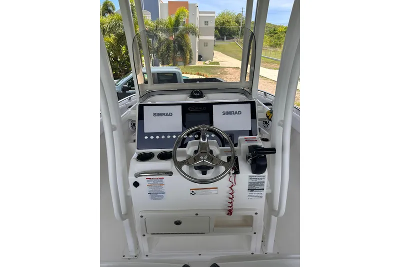 Slide: The Image of 2023 Robalo R222 Explorer boat dashboard with dual Simrad displays and steering wheel. - 9