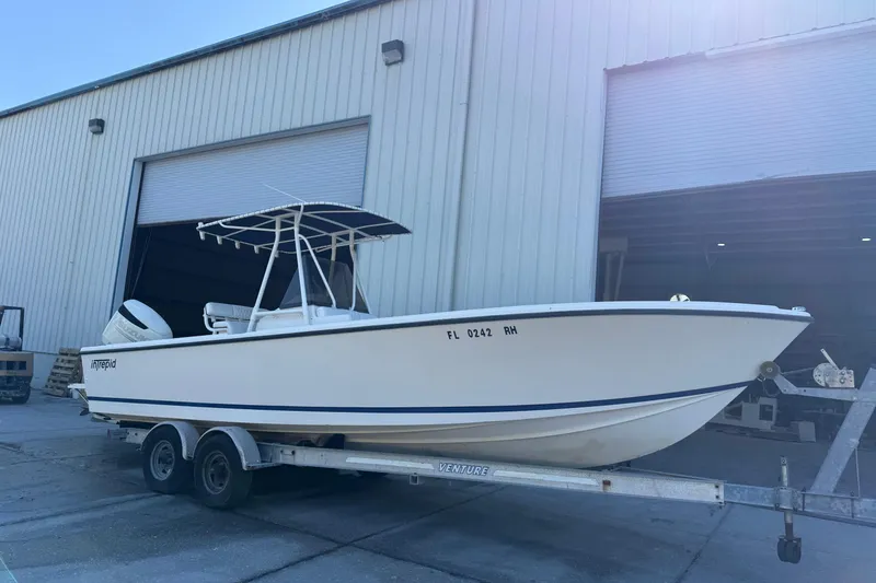 Slide: The Image of 1993 Intrepid 26 Walkaround boat on trailer outside warehouse. - 10