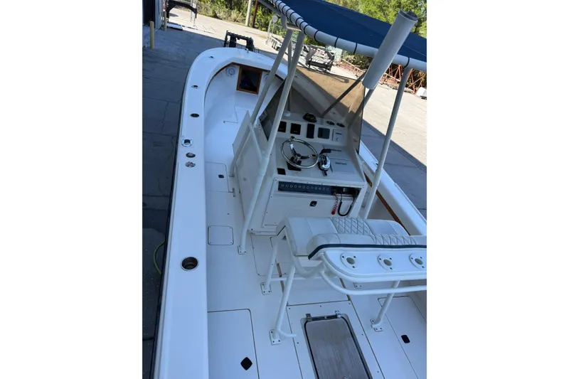 The Image of 1993 Intrepid 26 Walkaround boat with helm, seating, and canopy in a marina setting. - 1