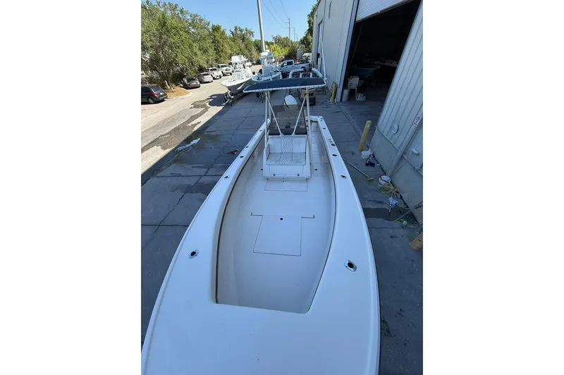 Slide: The Image of 1993 Intrepid 26 Walkaround boat docked near a warehouse, ready for adventure. - 5