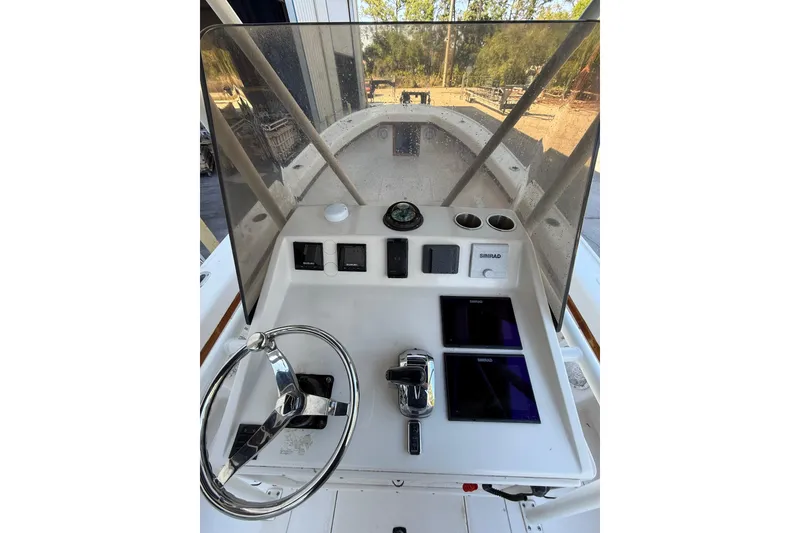 Slide: The Image of 1993 Intrepid 26 Walkaround boat helm with steering wheel, controls, and Simrad displays. - 7