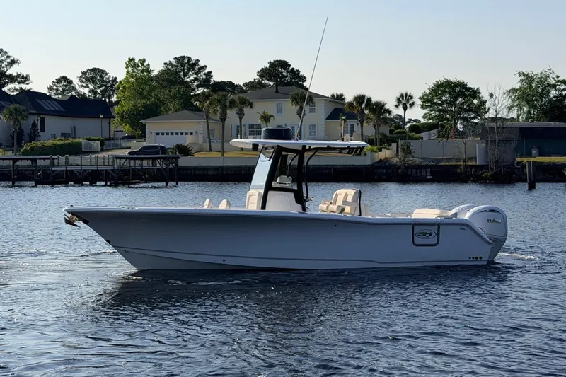 The Image of 2024 Sea Hunt Ultra 275 SE boat on calm water near residential area. - 1