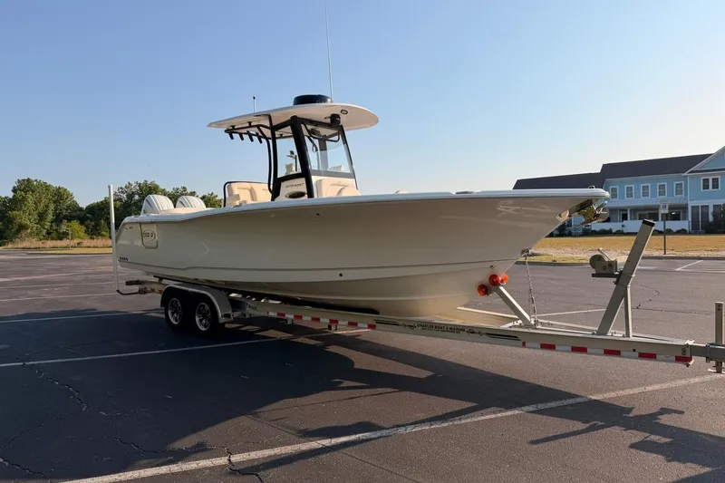 Slide: The Image of 2024 Sea Hunt Ultra 275 SE boat on trailer in parking lot, sunny day. - 11