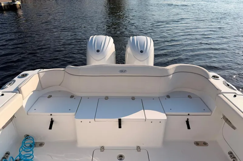 Slide: The Image of 2024 Sea Hunt Ultra 275 SE boat with dual engines on calm water. - 12