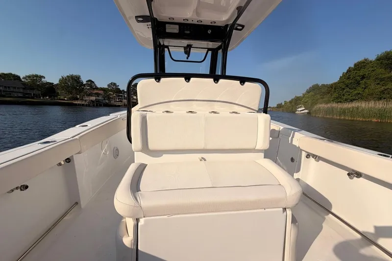 Slide: The Image of 2024 Sea Hunt Ultra 275 SE boat interior with seating, on a calm river. - 14