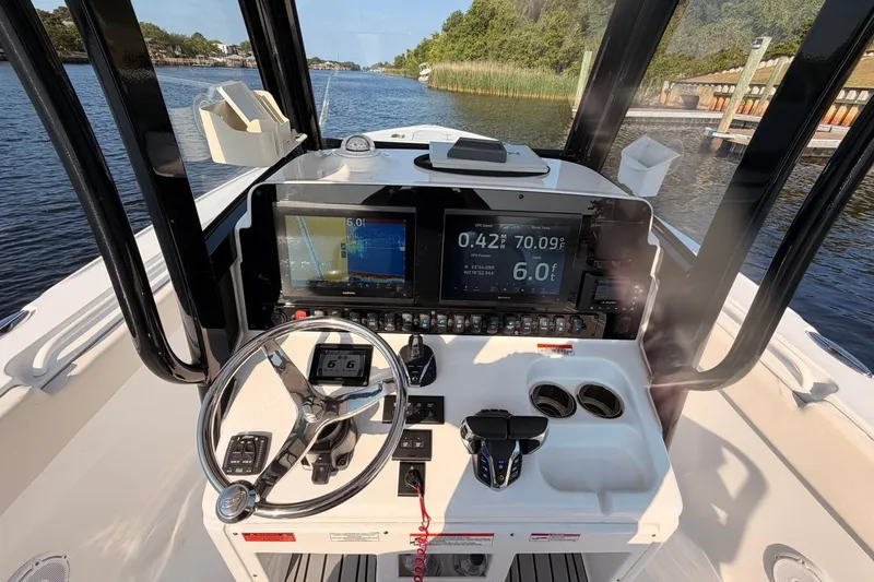 Slide: The Image of 2024 Sea Hunt Ultra 275 SE boat dashboard with navigation screens and steering wheel. - 15