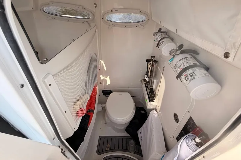 Slide: The Image of 2024 Sea Hunt Ultra 275 SE boat interior with toilet and safety equipment. - 19