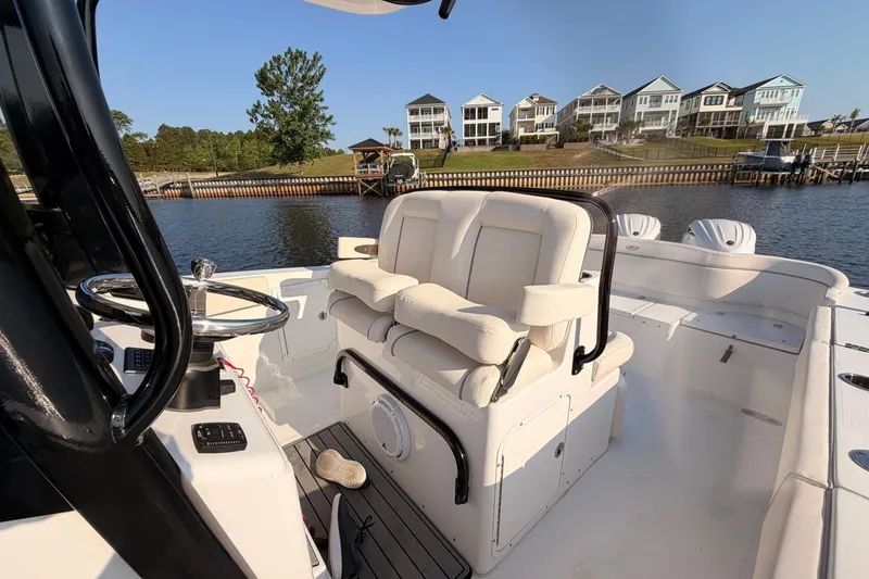 Slide: The Image of 2024 Sea Hunt Ultra 275 SE boat interior with helm and seating, dockside view. - 20