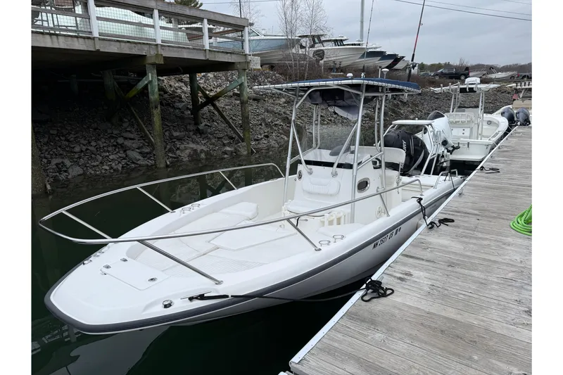 The Image of 2008 Boston Whaler 230 Dauntless boat docked at a marina, featuring sleek design and spacious deck. - 0