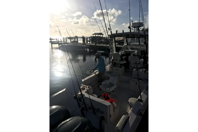 Slide: The Image of 2003 Grady-White Sailfish 282 docked at marina during sunset, fishing rods visible. - 4
