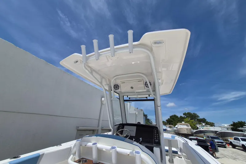 Slide: The Image of 2026 Robalo R250 Center Console boat with T-top under clear blue sky. - 15