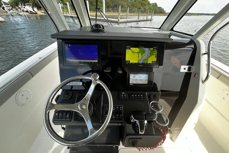Slide: The Image of Cockpit of 2023 Pursuit S 328 Sport boat with advanced navigation displays. - 10