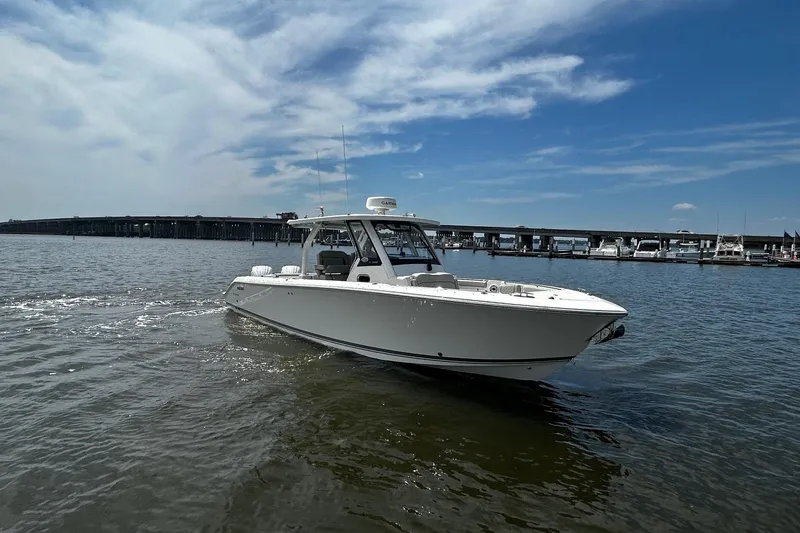 Slide: The Image of 2023 Pursuit S 328 Sport boat cruising on a sunny day near a marina. - 4