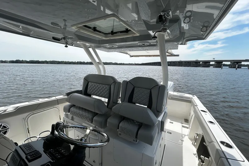 Slide: The Image of 2023 Pursuit S 328 Sport boat interior with dual seats and steering wheel on open water. - 8