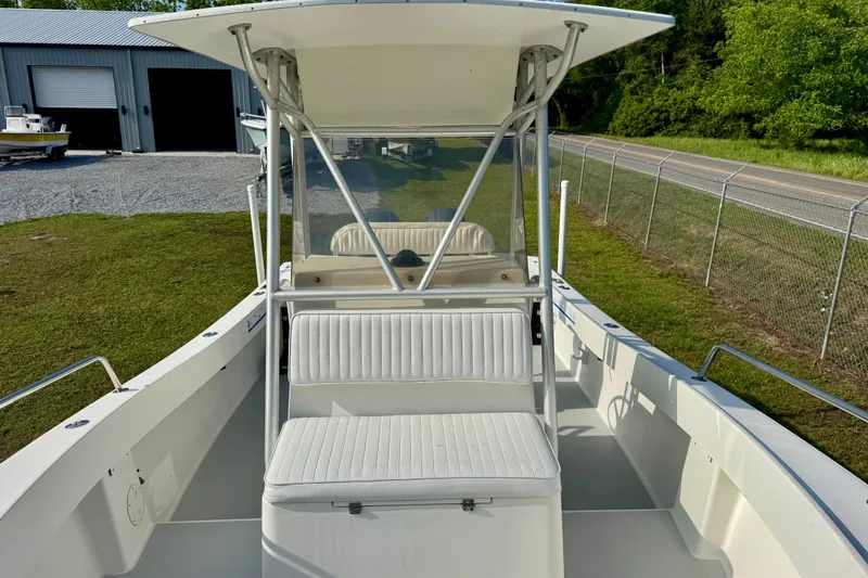 Slide: The Image of 1994 Regulator 23 Center Console boat with white seating and T-top, parked outdoors. - 9