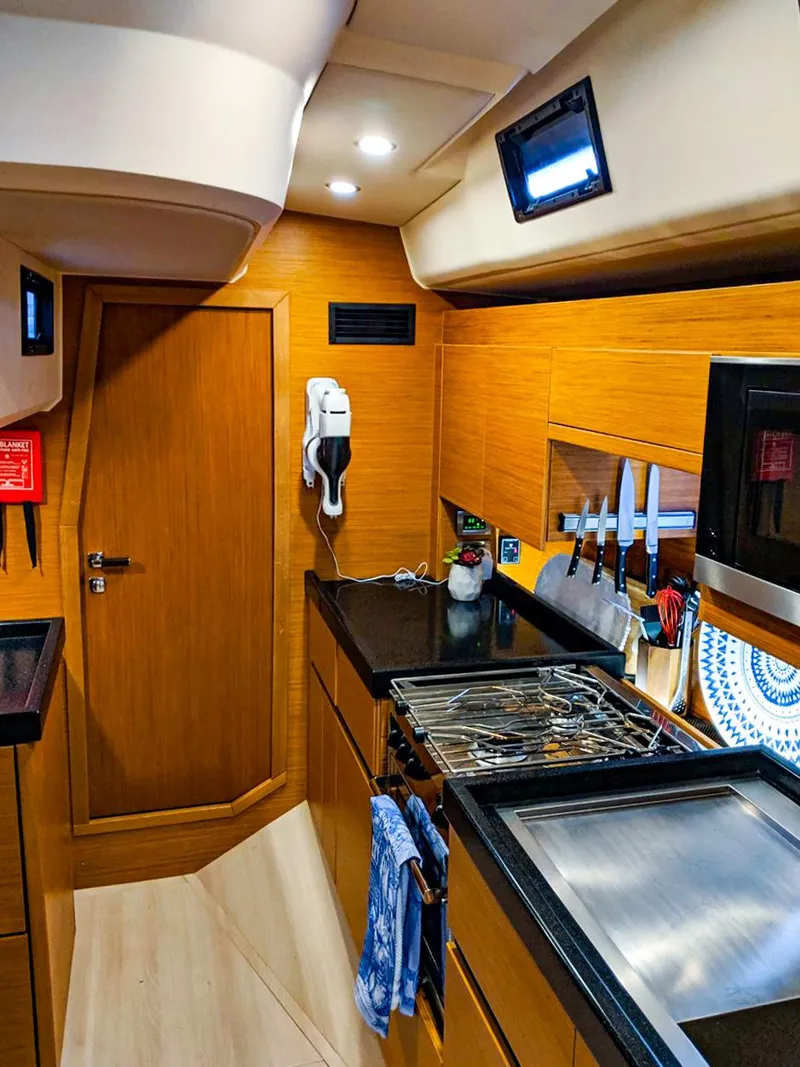 Slide: The Image of Modern kitchen interior of 2018 Hanse 675 yacht with wooden cabinetry and appliances. - 12