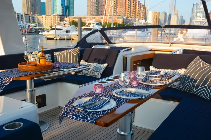 Slide: The Image of Luxurious 2018 Hanse 675 yacht deck with elegant dining setup in marina. - 2