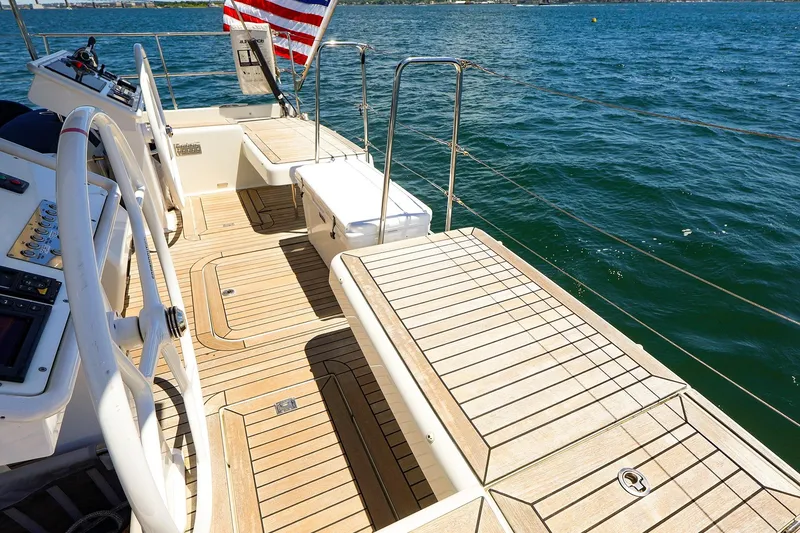 Slide: The Image of 2018 Hanse 675 yacht deck with steering wheel, wooden flooring, and ocean view. - 20