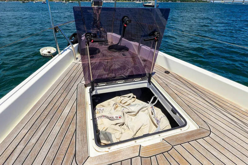 Slide: The Image of Open hatch on 2018 Hanse 675 yacht deck with stored sails visible. - 31