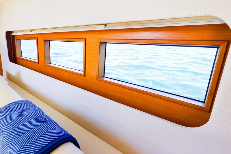 Slide: The Image of Interior view of 2018 Hanse 675 yacht, showcasing elegant wooden-framed windows and ocean view. - 47