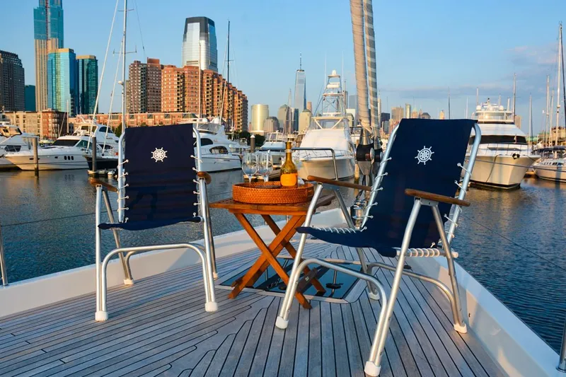 Slide: The Image of Luxury Hanse 675 yacht deck with chairs, table, and city skyline view, 2018 model. - 5