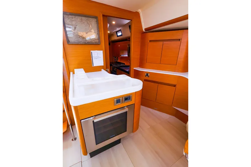Slide: The Image of Interior of 2018 Hanse 675 yacht featuring modern kitchen with wood cabinetry and sleek appliances. - 52