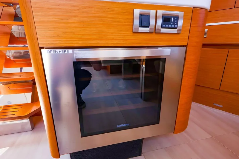 Slide: The Image of Modern kitchen appliance on 2018 Hanse 675 yacht, featuring sleek wood and stainless steel design. - 53