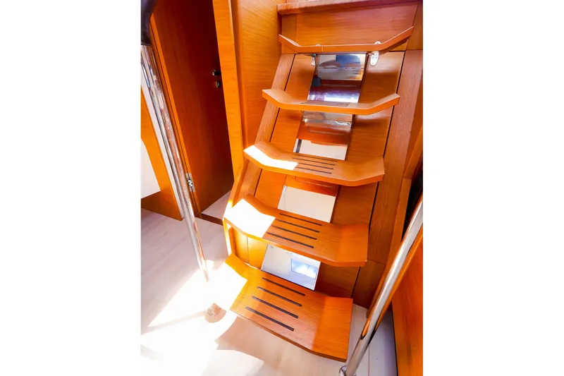 Slide: The Image of Wooden staircase inside 2018 Hanse 675 yacht, featuring sleek design and polished metal accents. - 54