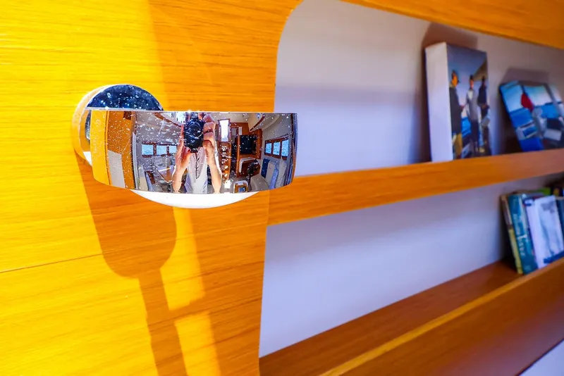 Slide: The Image of Interior of 2018 Hanse 675 yacht with wooden shelves and reflective chrome fixture. - 55