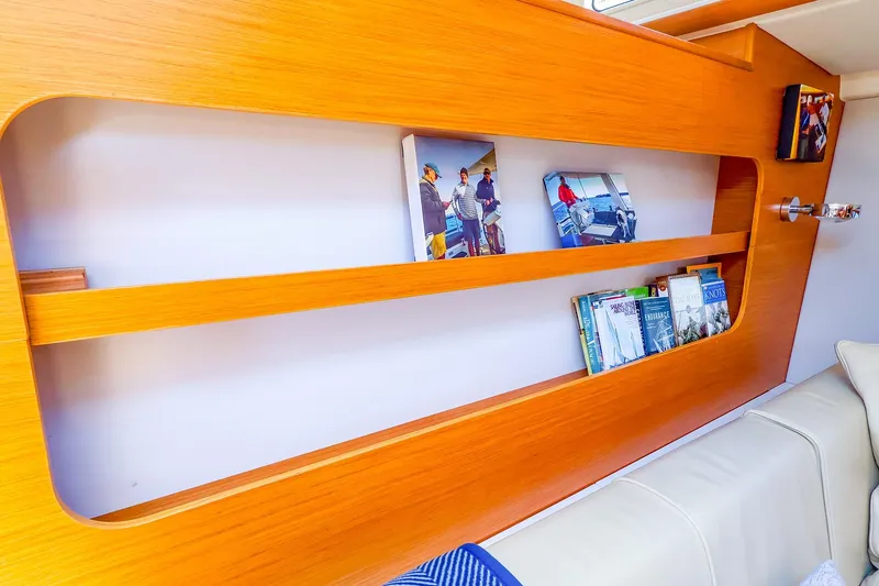 Slide: The Image of Interior of 2018 Hanse 675 yacht with wooden shelves and books. - 56